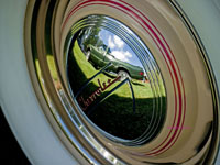 1970s Chevrolet truck reflected in a 1937 Chevrolet hubcap